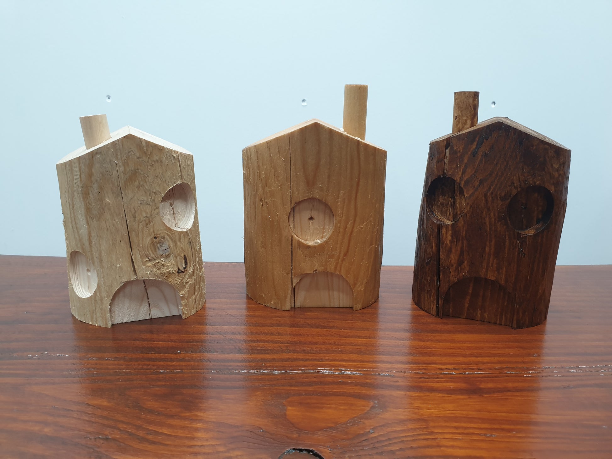 A photo of 3 20cm fairy houses. Various details on them, 1 untreated, 1 danish oiled and 1 in dark oak stain.