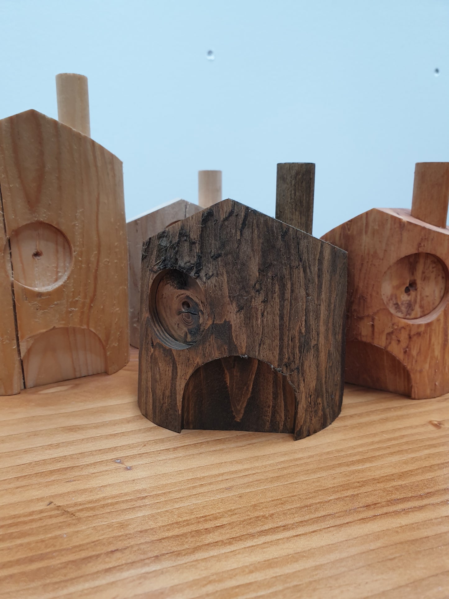 A close up of the 15cm dark oak stained fairy house. It has a central door and an offset window to the left above with a chimney on the roof to the right.