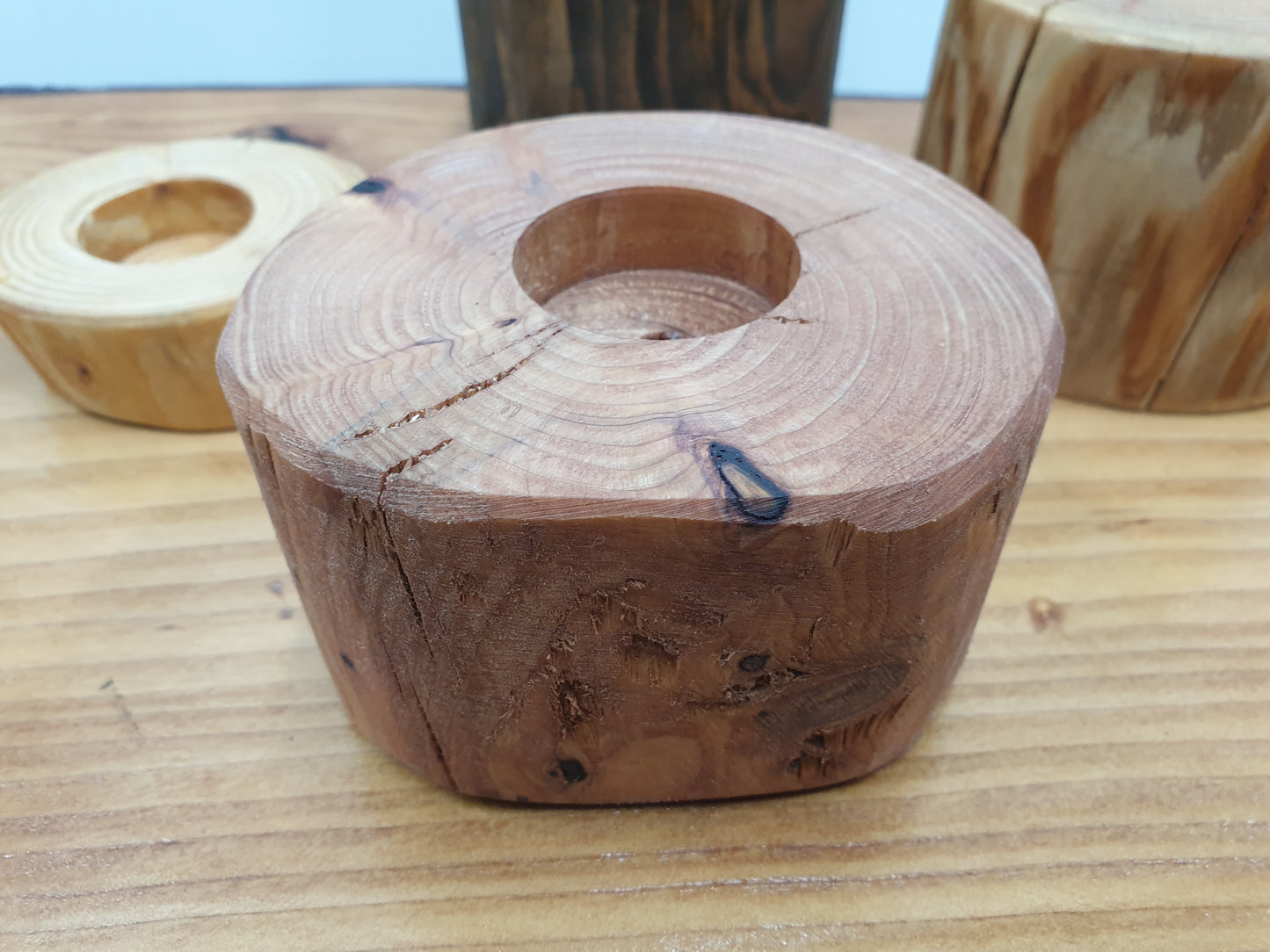 A medium height tea light holder with a red cedar stain