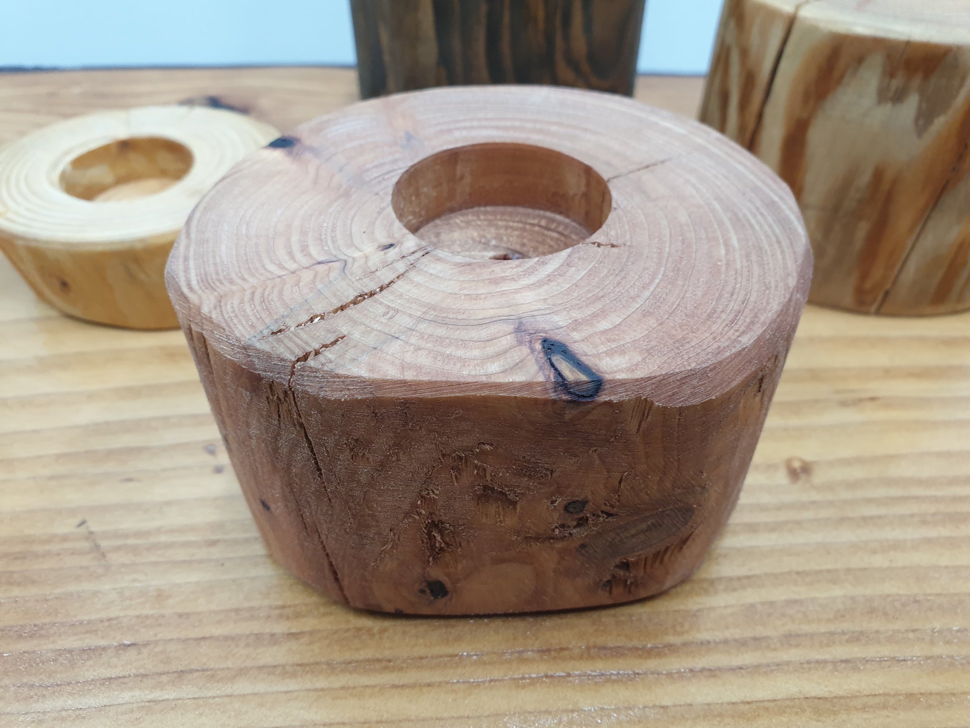 A medium height tea light holder with a red cedar stain
