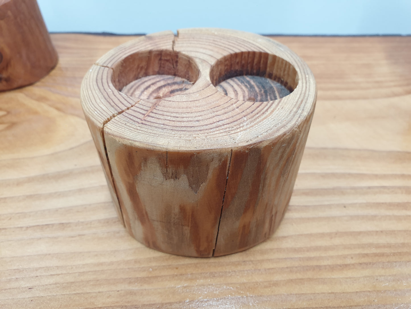 A closeup of a tall log tea light holder with 2 candle holes.