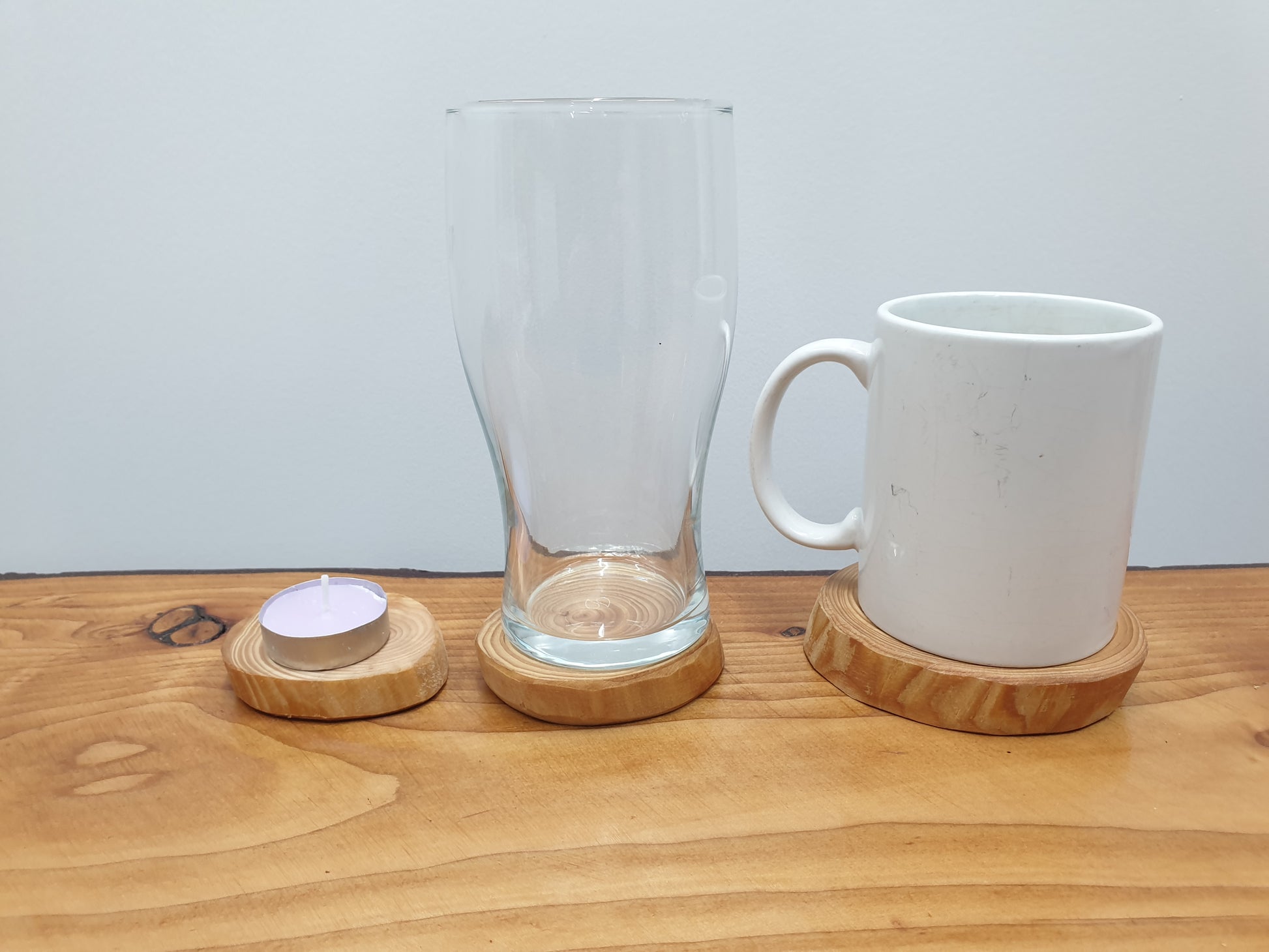 An example of three different coasters being used for three different sized items; a tea-light, a glass, and a mug