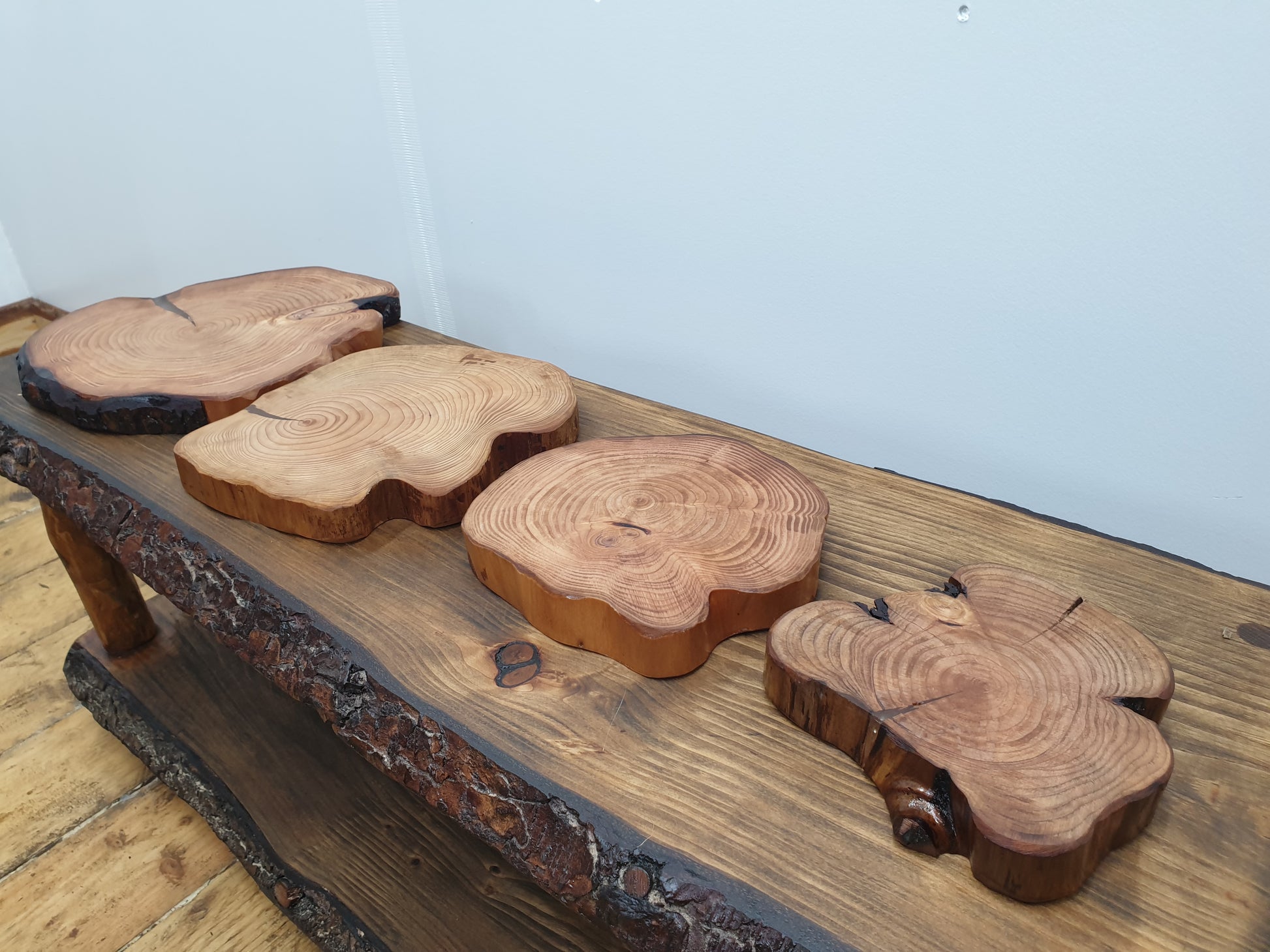 Four log ring place mats arranged alongside one another on a coffee table to compare their appearance