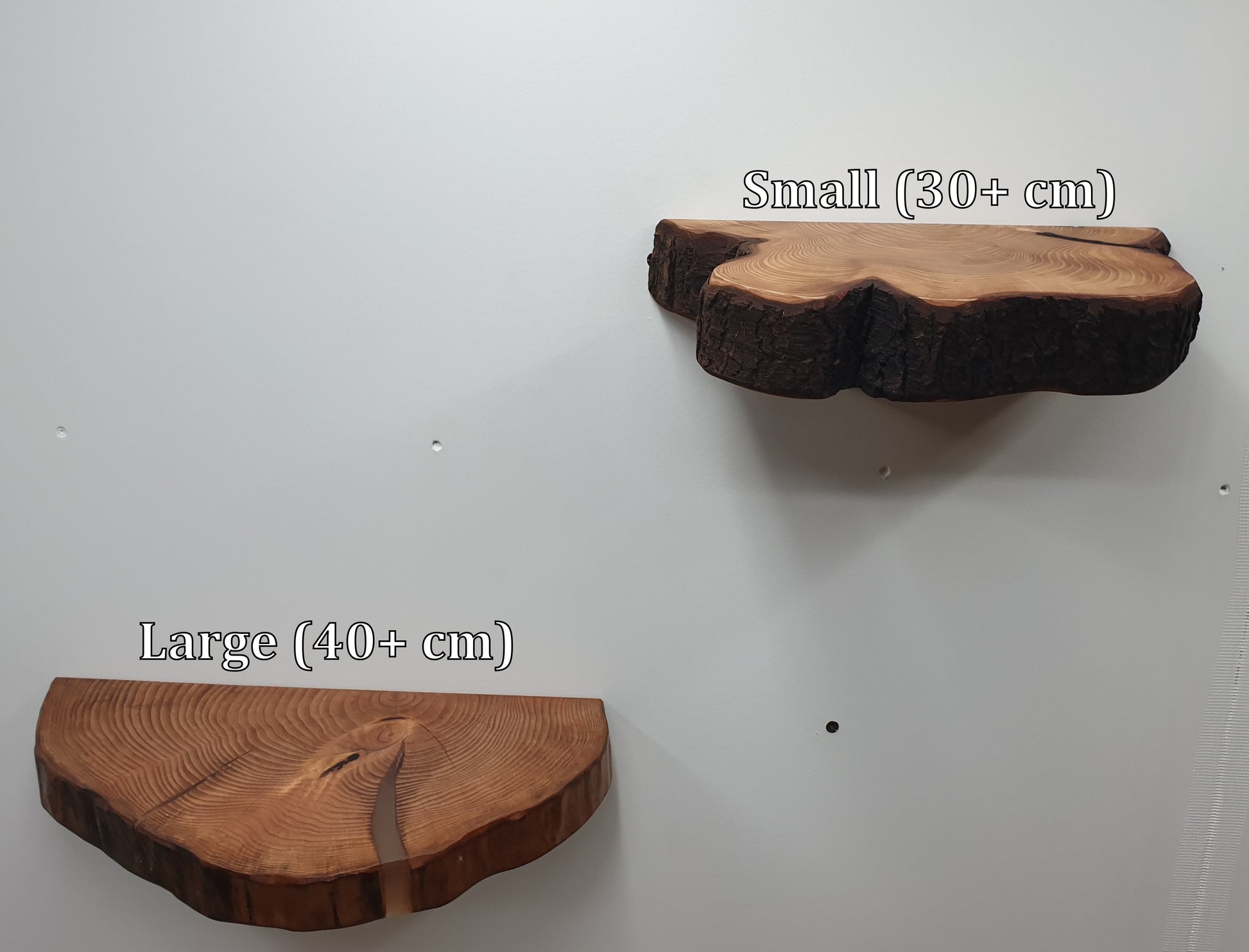 a pair of half log ring floating shelves mounted on a white wall with the labels "Small (30+ cm)" and "Large (40+ cm)"