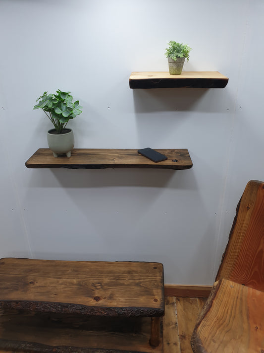 A view of two wooden wall shelves in a studio living room scene with a wooden chair and a live-edge coffee table