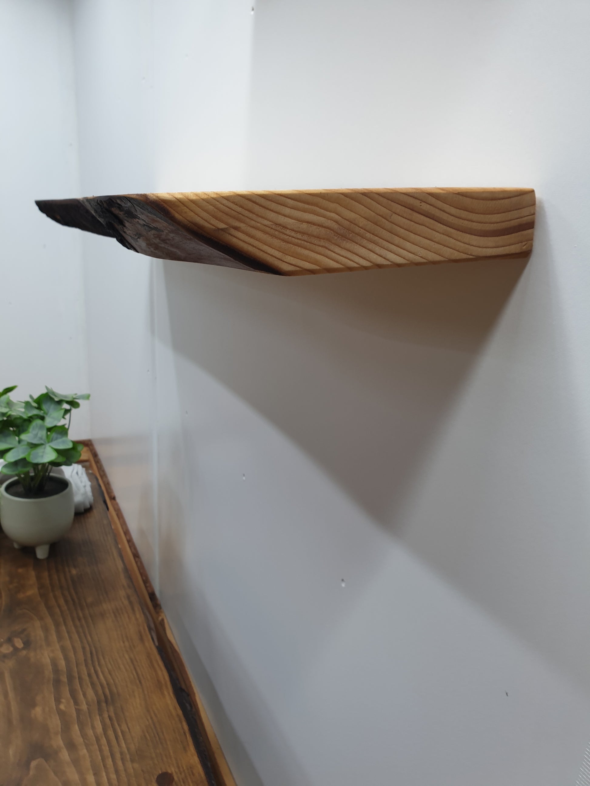 A side view of a wooden floating shelf showing its thickness