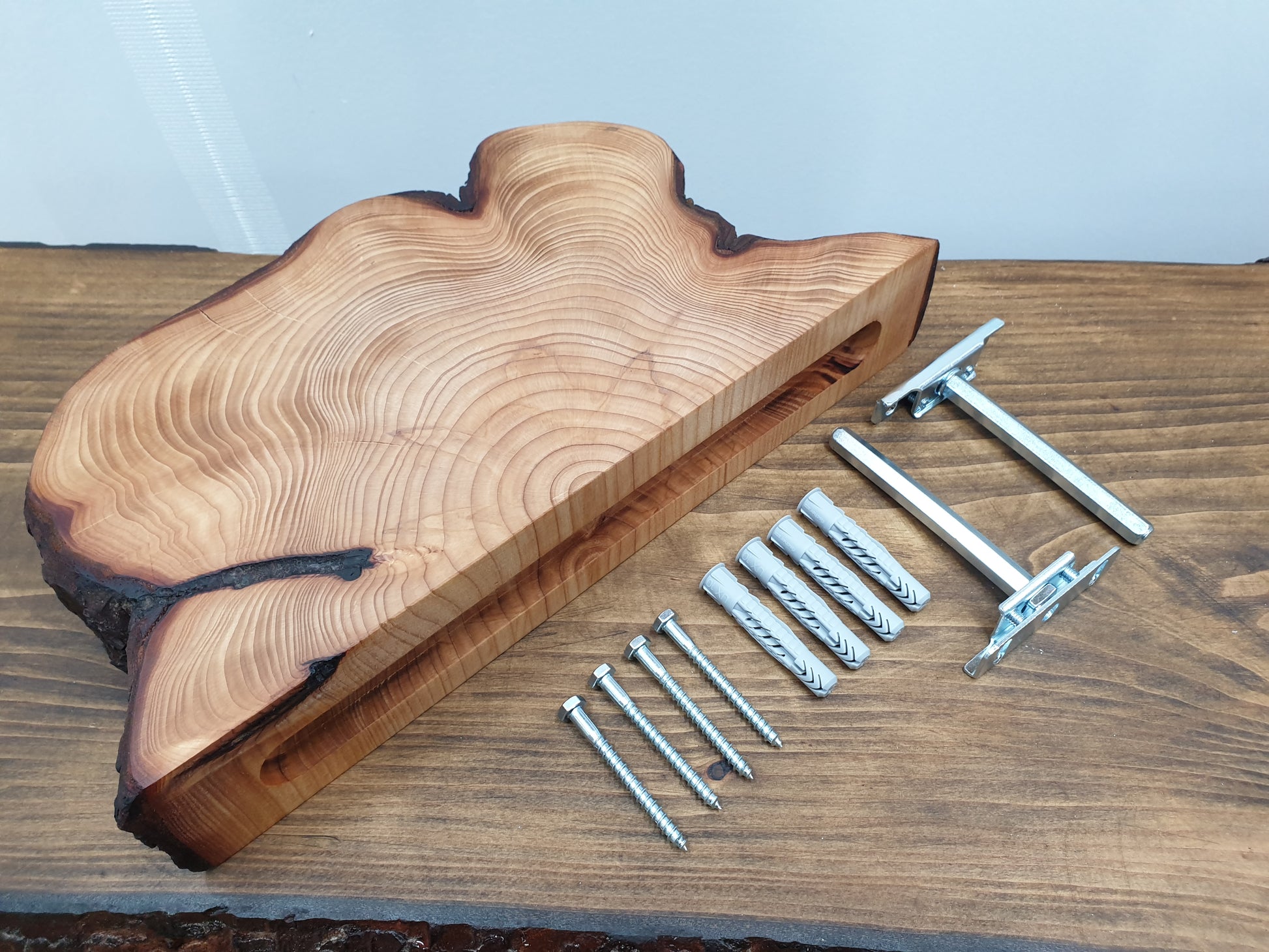 a half log ring floating shelf arranged with the brackets, screws, and wall plugs needed to mount it
