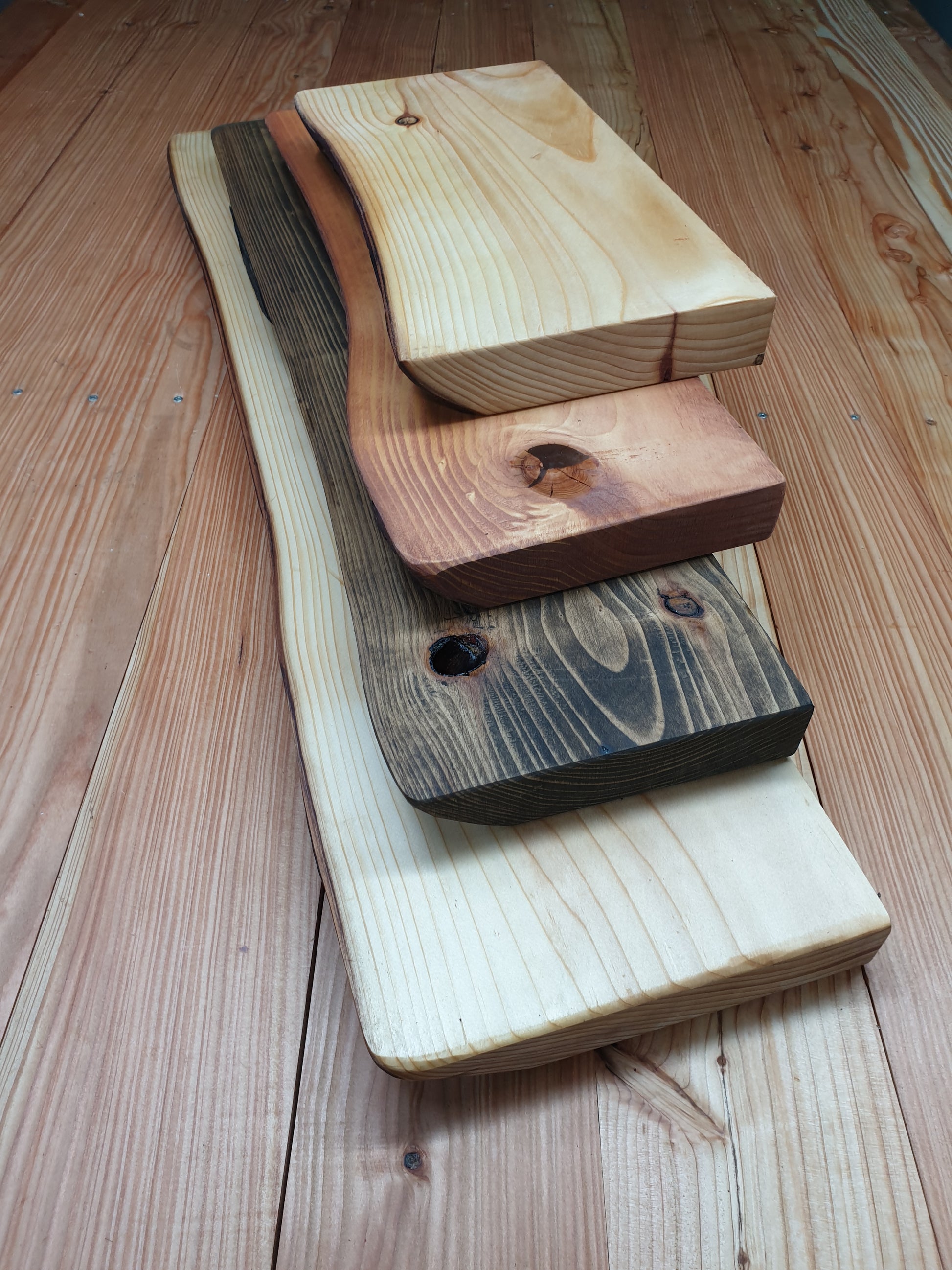 A view of four different wooden floating shelves to compare sizes and colour