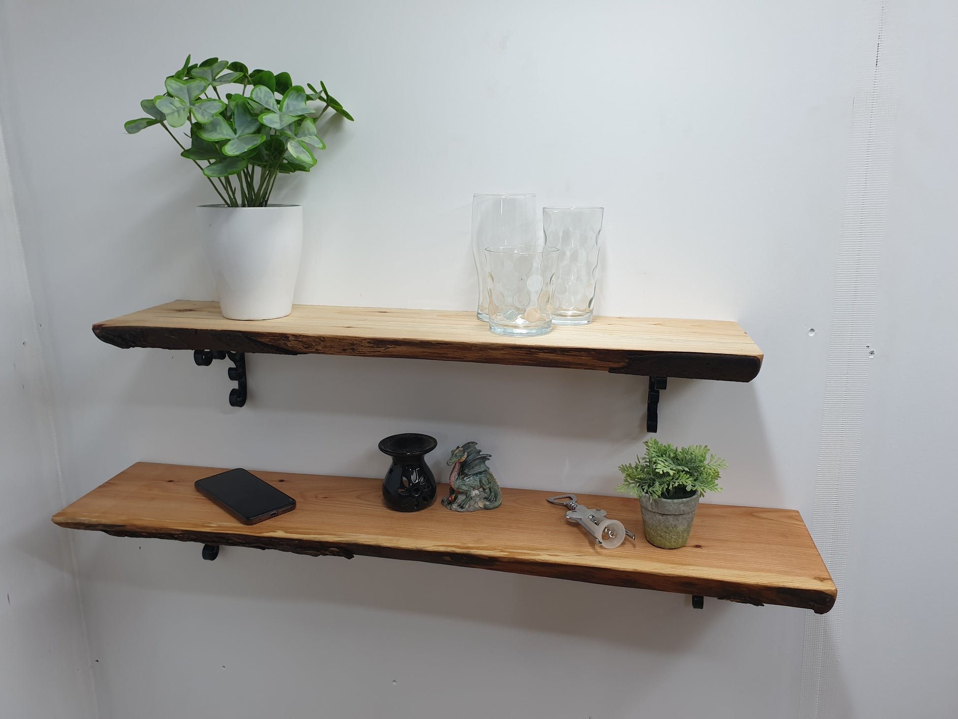 two live-edge wooden shelves with various items arranged on them