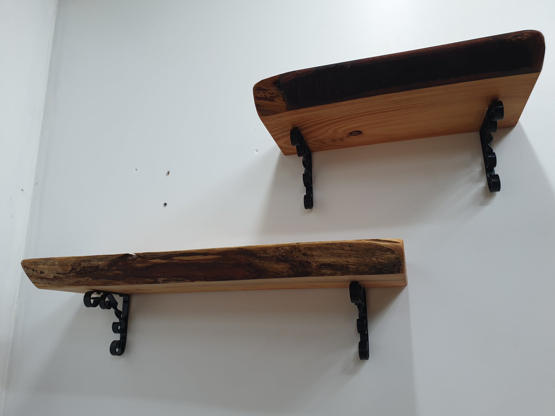 underside view of two shelves and their ornamental scroll brackets