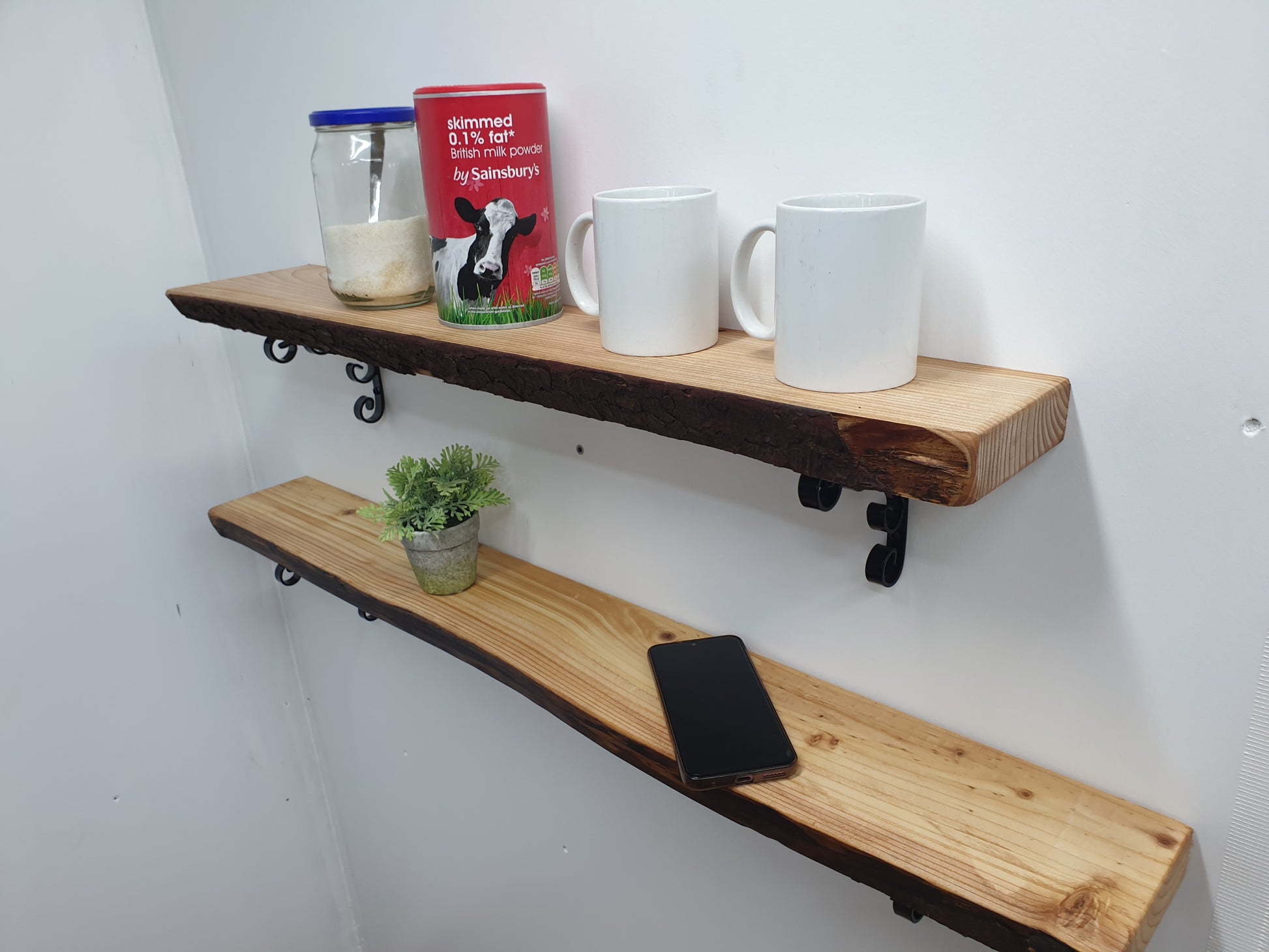 two shelves being used to store cups and tea ingredients