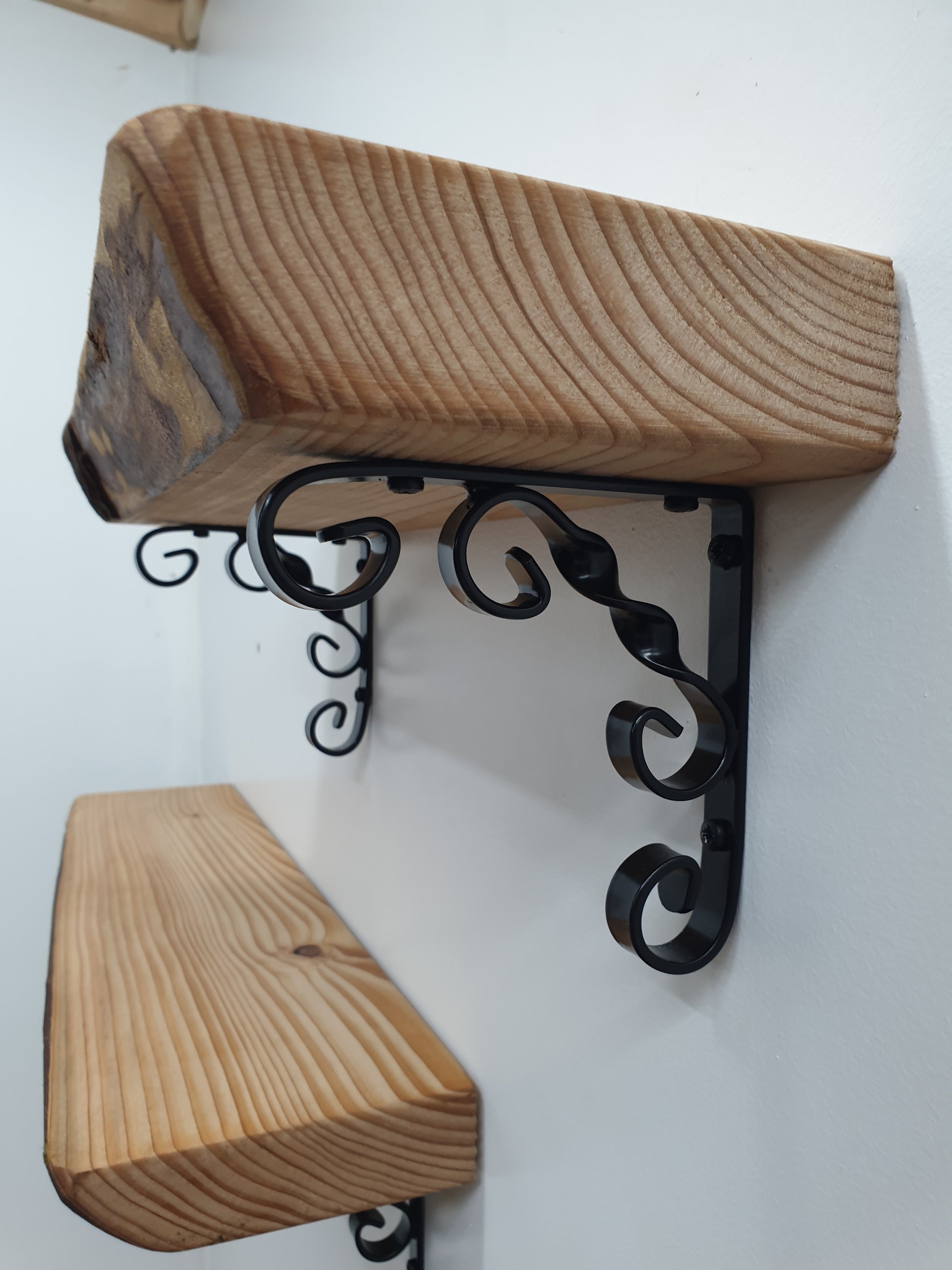 close up of an ornamental scroll bracket being used to hold a shelf