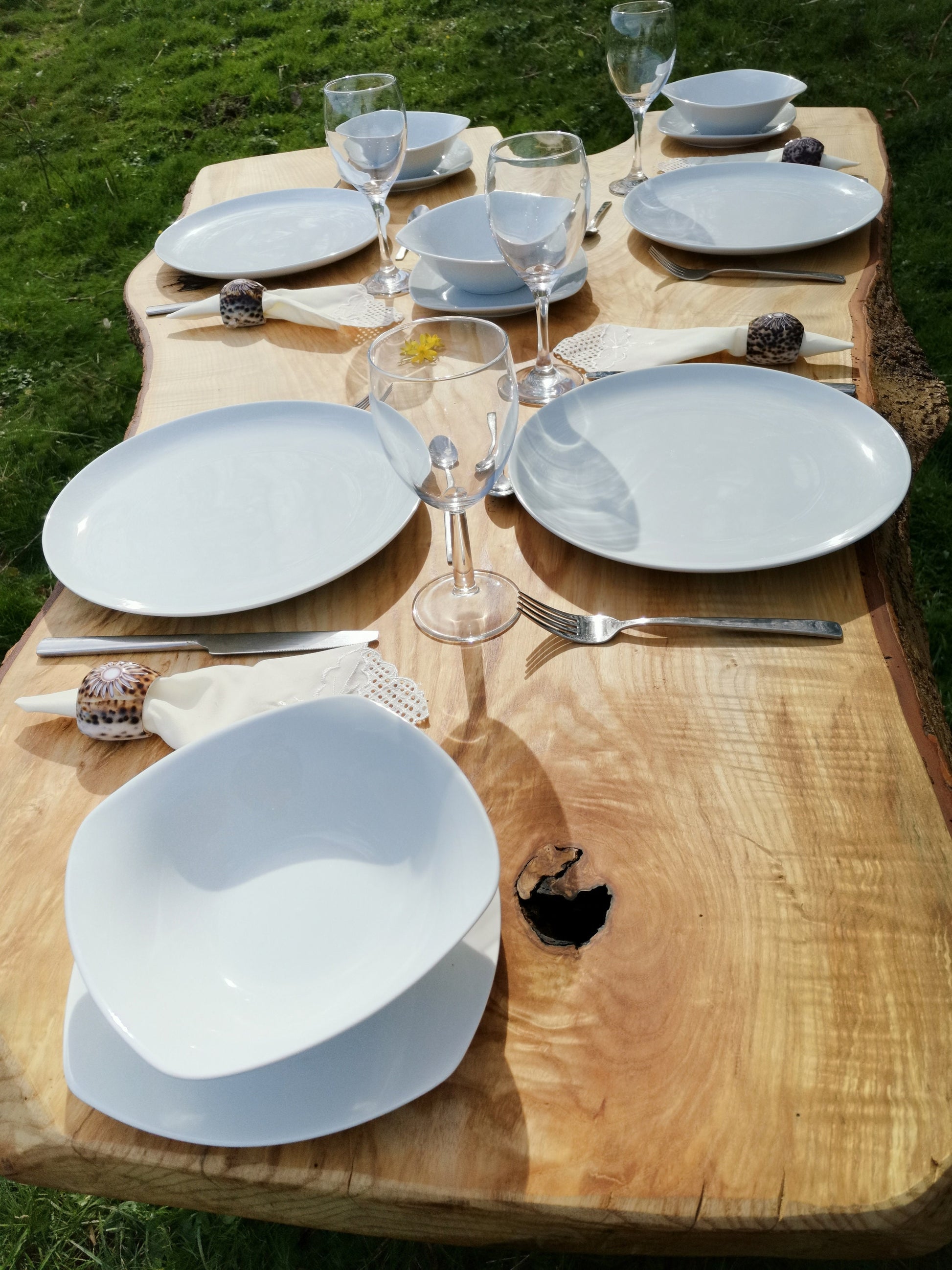 plates and glasses on a wooden table outside