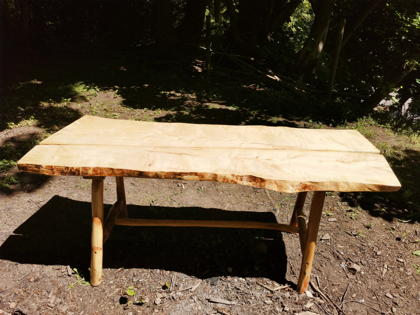 a sycamore garden table in a forest scene