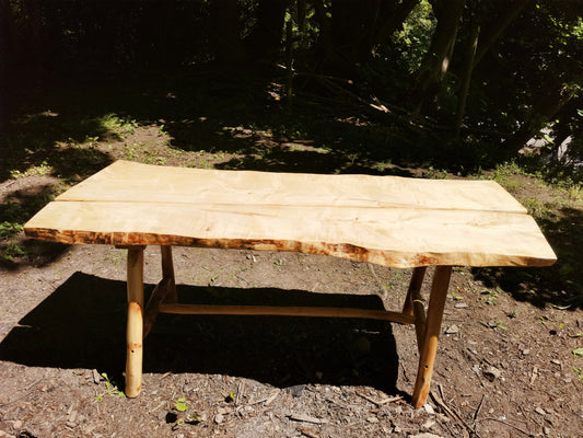 a sycamore garden table in a forest scene