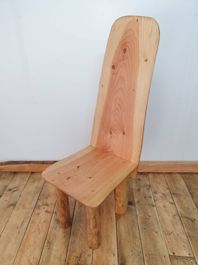A wooden throne with a long back against a studio background.