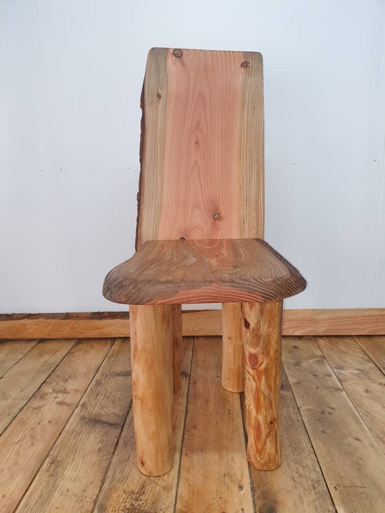 A straight on view of a short-backed chair that focuses on the height of the legs in comparison to the back