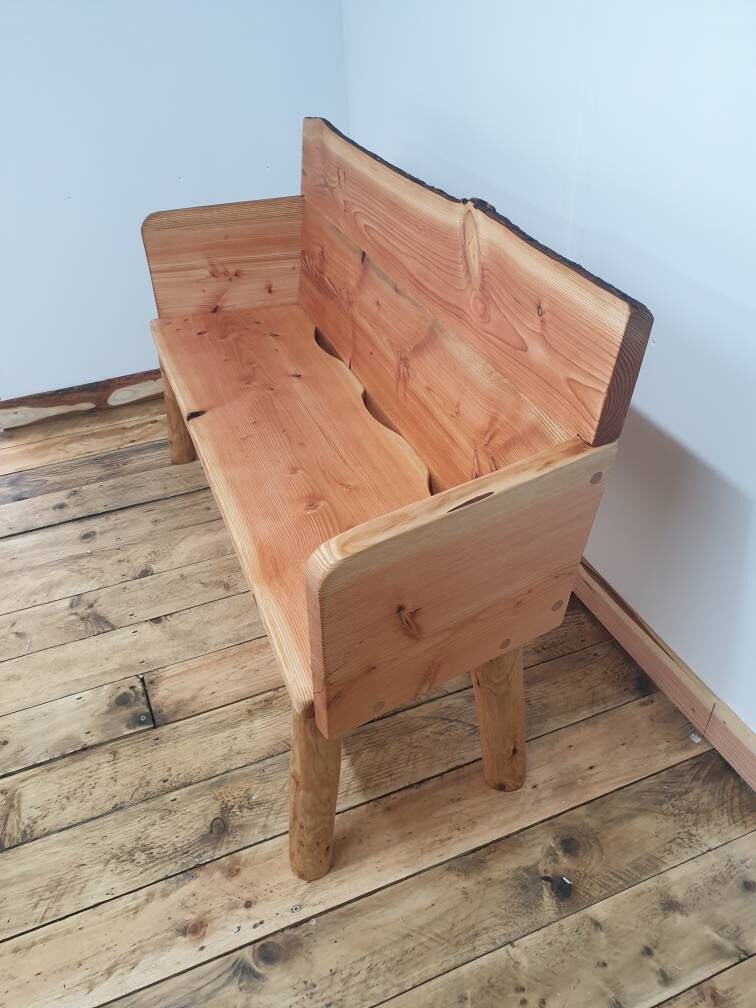 Side view of a wooden garden bench with back support