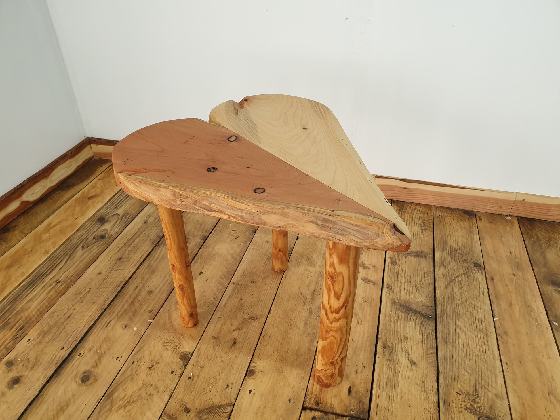A photo from the left aspect of just the table, showing an array of colour and definition along its red wood live edge.