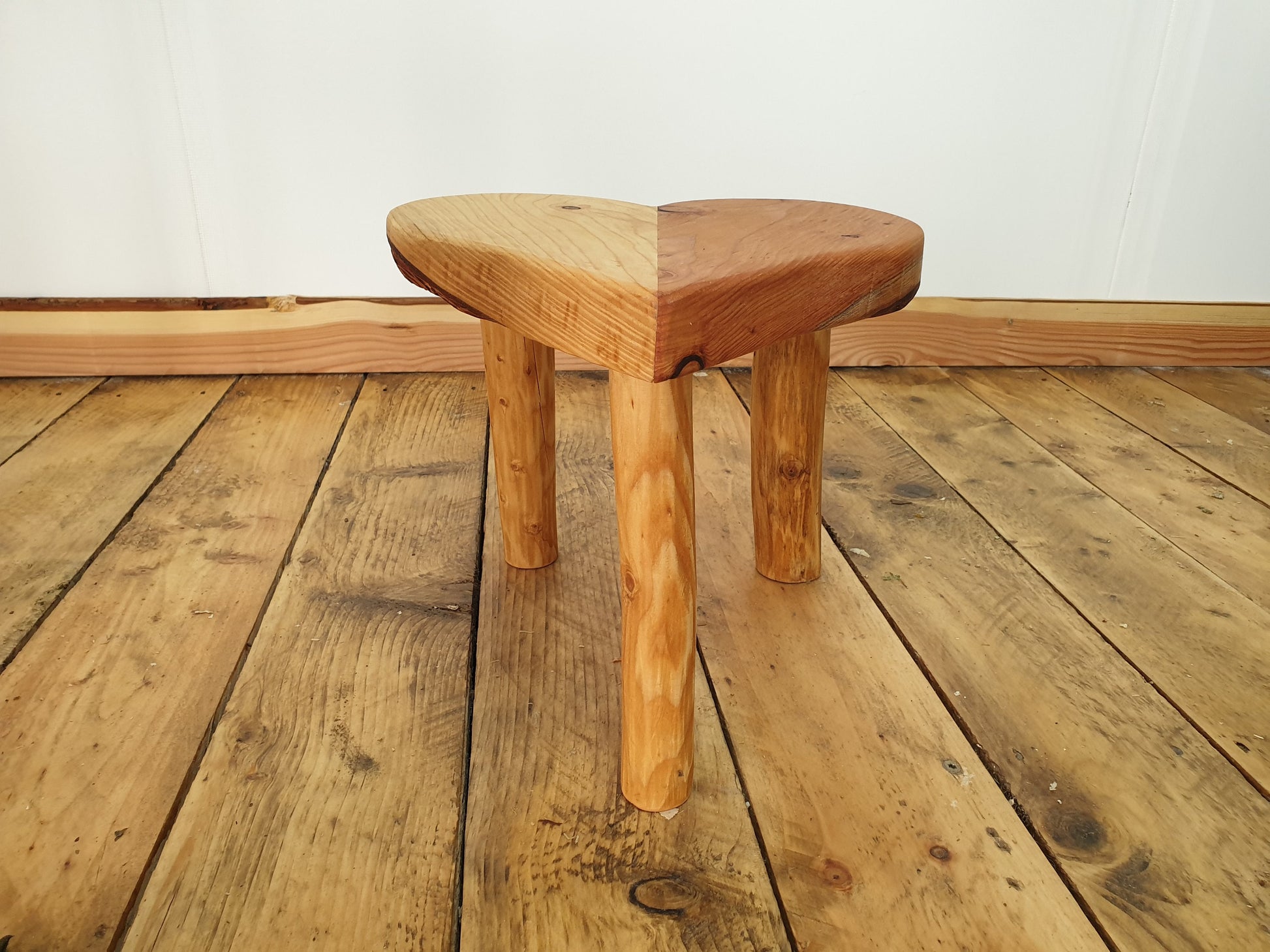A photo of just the stool from the the front lower aspect. It has traces of bark remaining on the underside of the seat base.