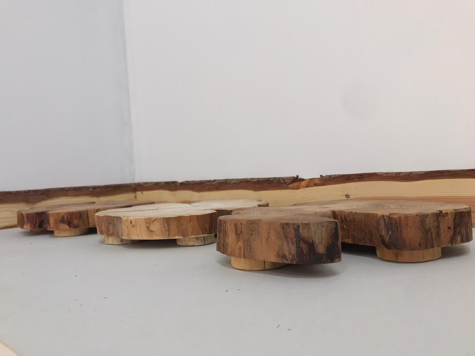 A side view of three log ring table centerpieces with feet.
