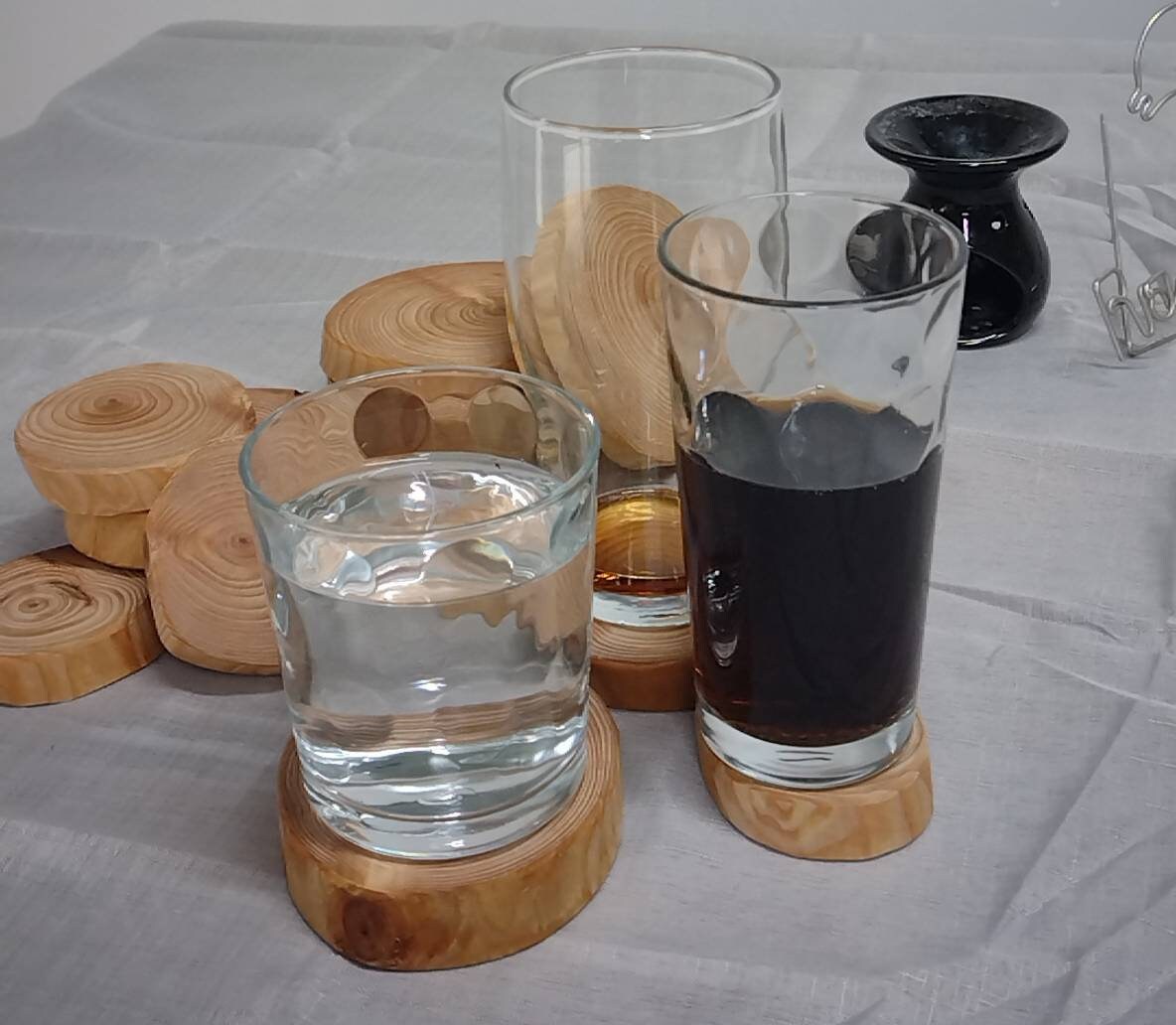 A selection of glasses sitting on top of log ring coasters