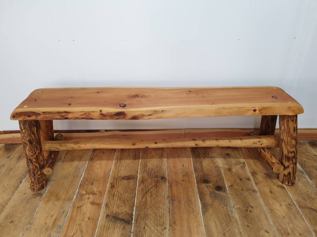 A side view of a wooden bench with tiger patterning on three of the legs.