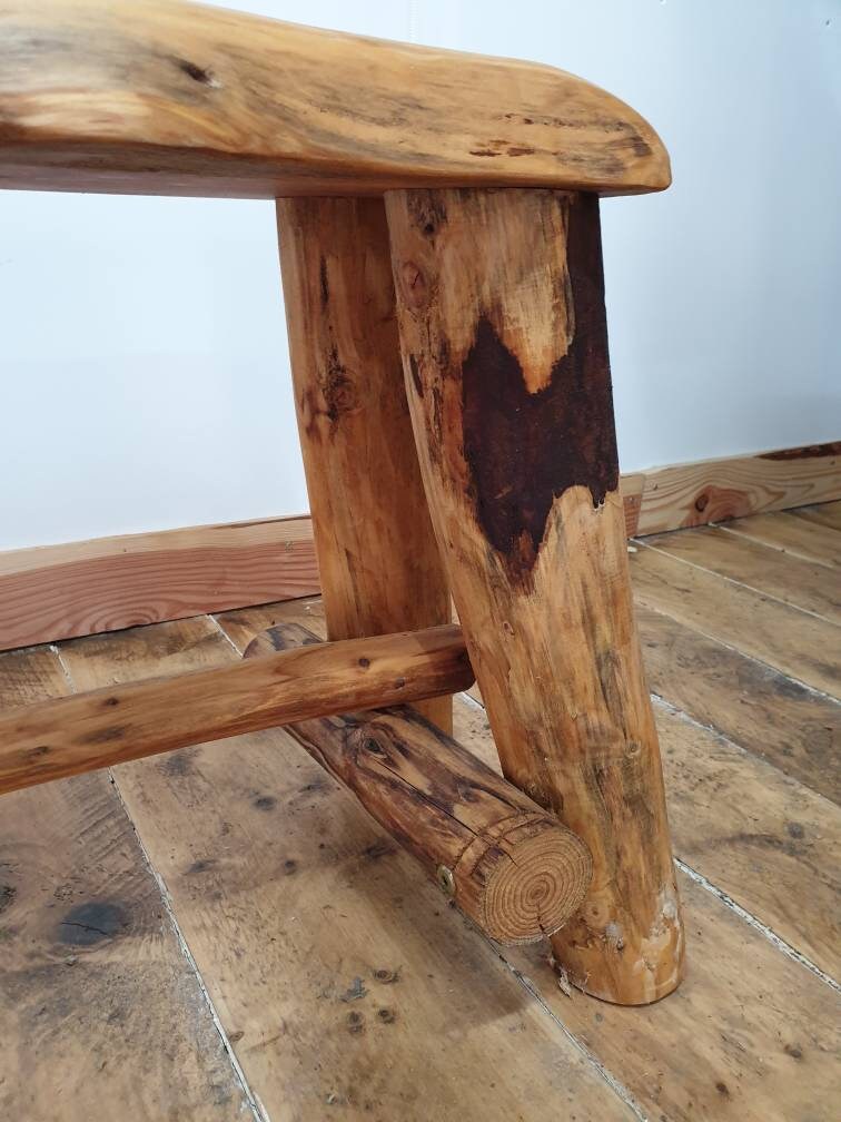 Closeup of the joints between the leg cross beams on a wooden bench.