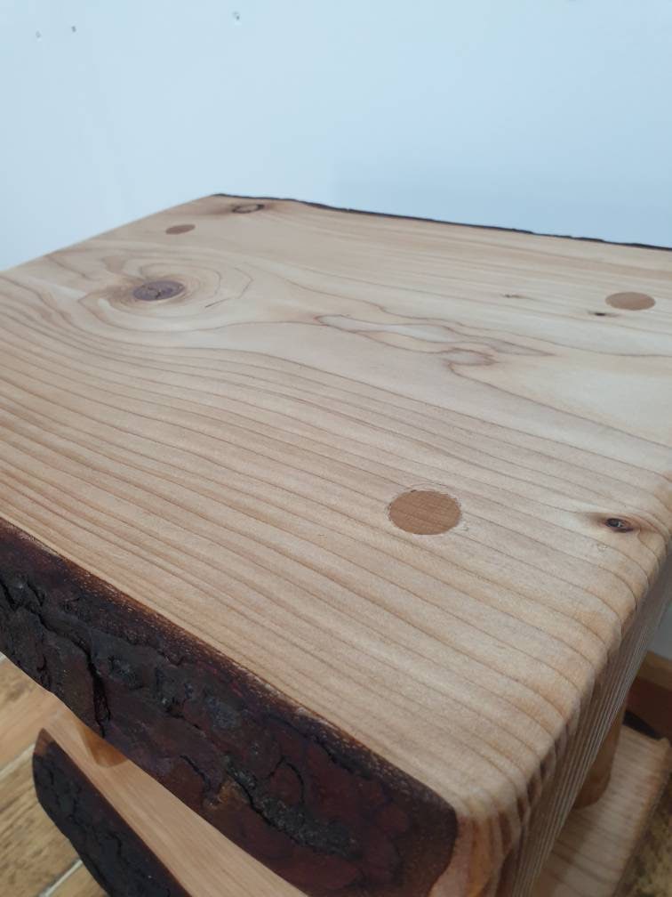 Closeup of the tabletop on a wooden bedside table. You can see the dowels used to hold the legs