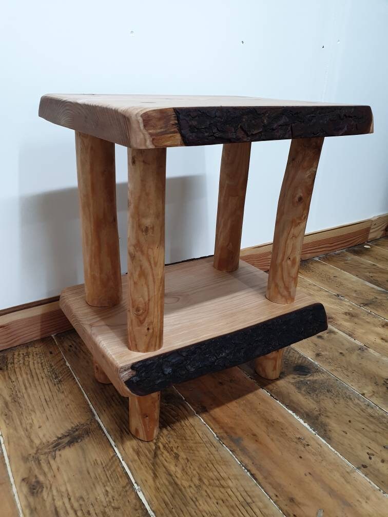 A view of a live-edge wooden bedside table showing the space available to the lower shelf