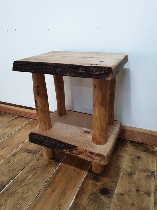 A wooden end table set up against a studio wall