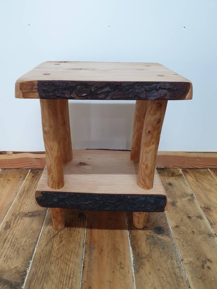 A view of a live edge wooden end/bedside table showing the bark still intact.