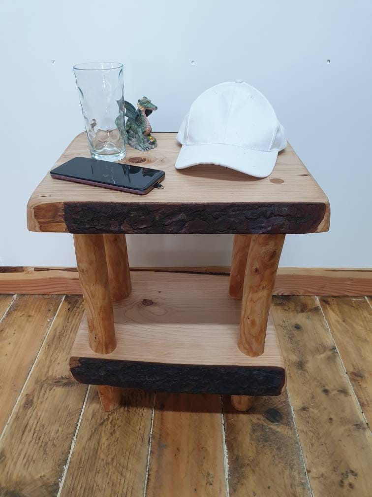 A rustic wooden nightstand or end table arranged with various objects