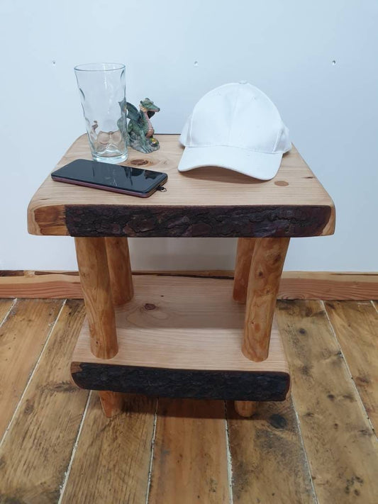 A rustic wooden nightstand or end table arranged with various objects