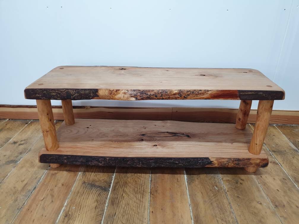 A wooden coffee table whose live-edge features a mixture of bark and cambium