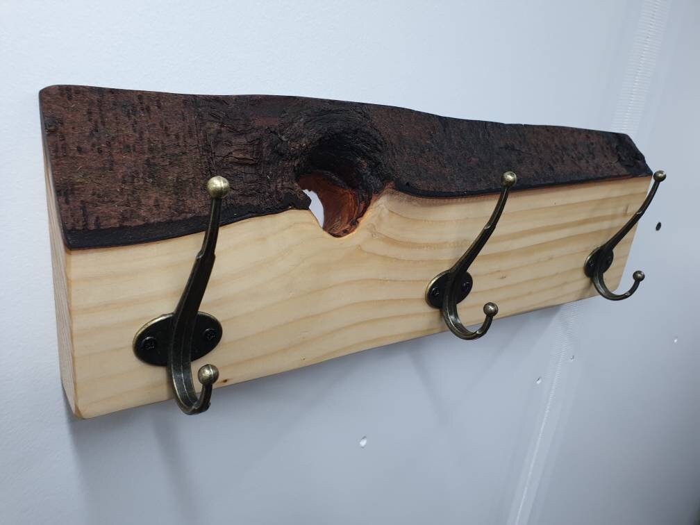 The 3 hook spruce coat rack with the natural hole from the left aspect.