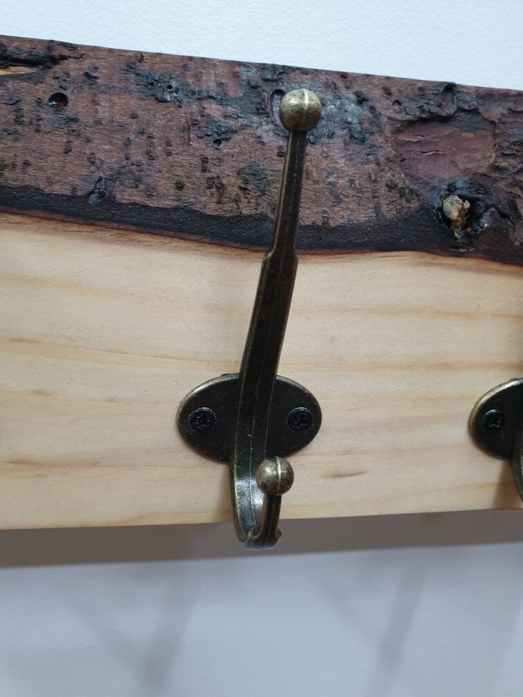 A close up of the hooks used. They are a double hook in a tarnished brass finish secured by 2 small black screws.