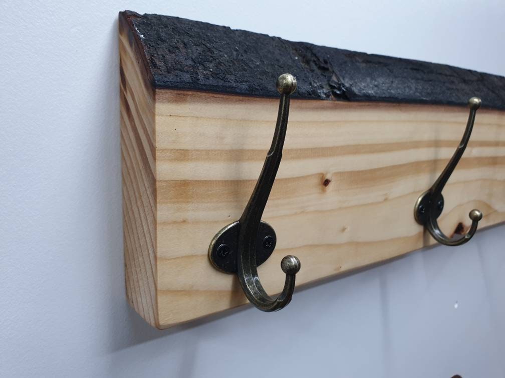 A photo from the left aspect of the end 2 hooks of the previously pictured coat rack.
