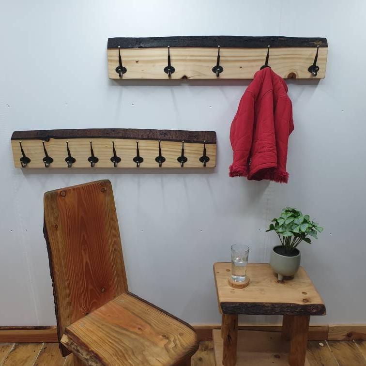 A front aspect of 2 90cm coat racks mounted on a white wall. The previously shown one with 9 hooks and another with just 5 widely spaced hooks and a small red coat hung up on it.