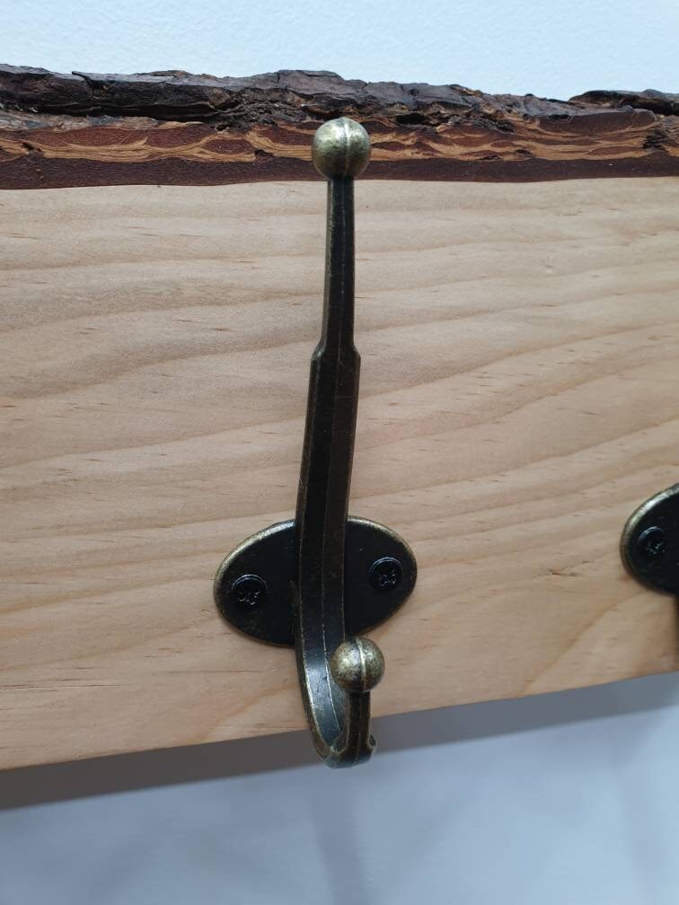 A close up of the hooks used. They are a double hook (one on top of the other) in a tarnished brass finish, secured by 2 small black countersunk screws.