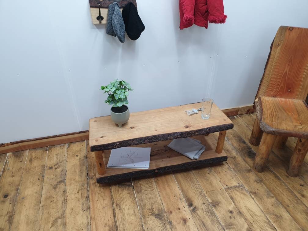 A studio scene of various wooden furniture including a two shelf coffee table, a throne and a coat rack