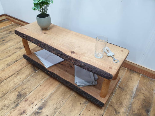 A wooden live-edge coffee table with lower shelf