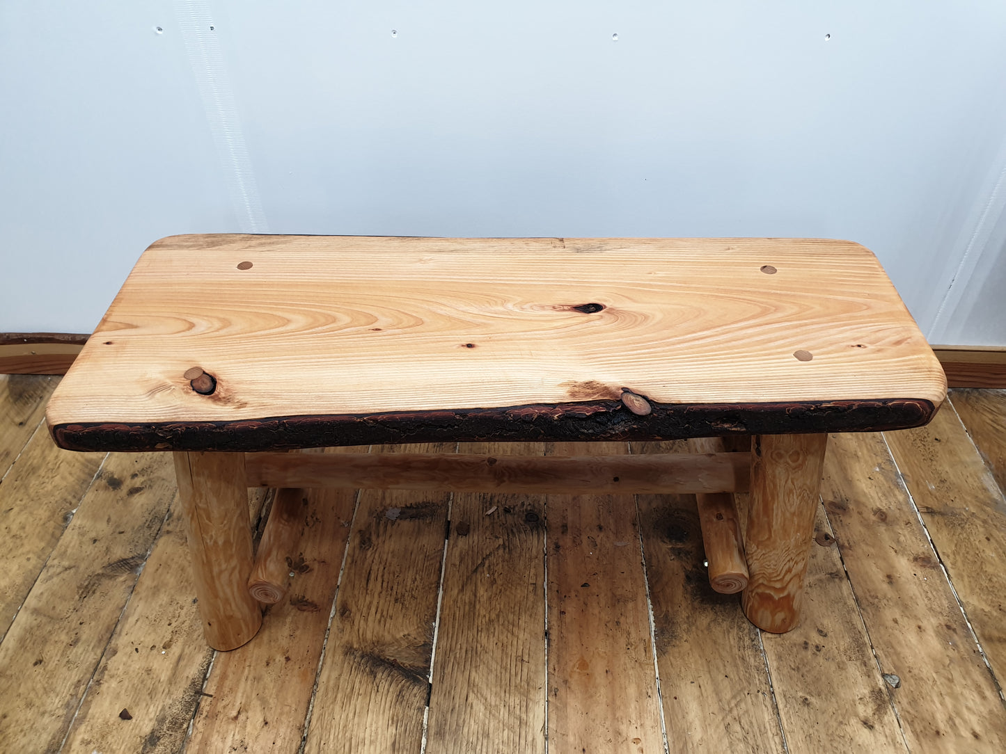 a short wooden bench that can seat two people.