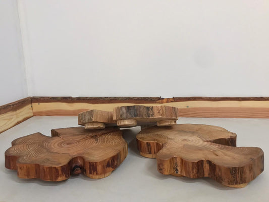 Two larger wooden table centerpieces fail to hold up their smaller friend as he tumbles backwards onto the ground.