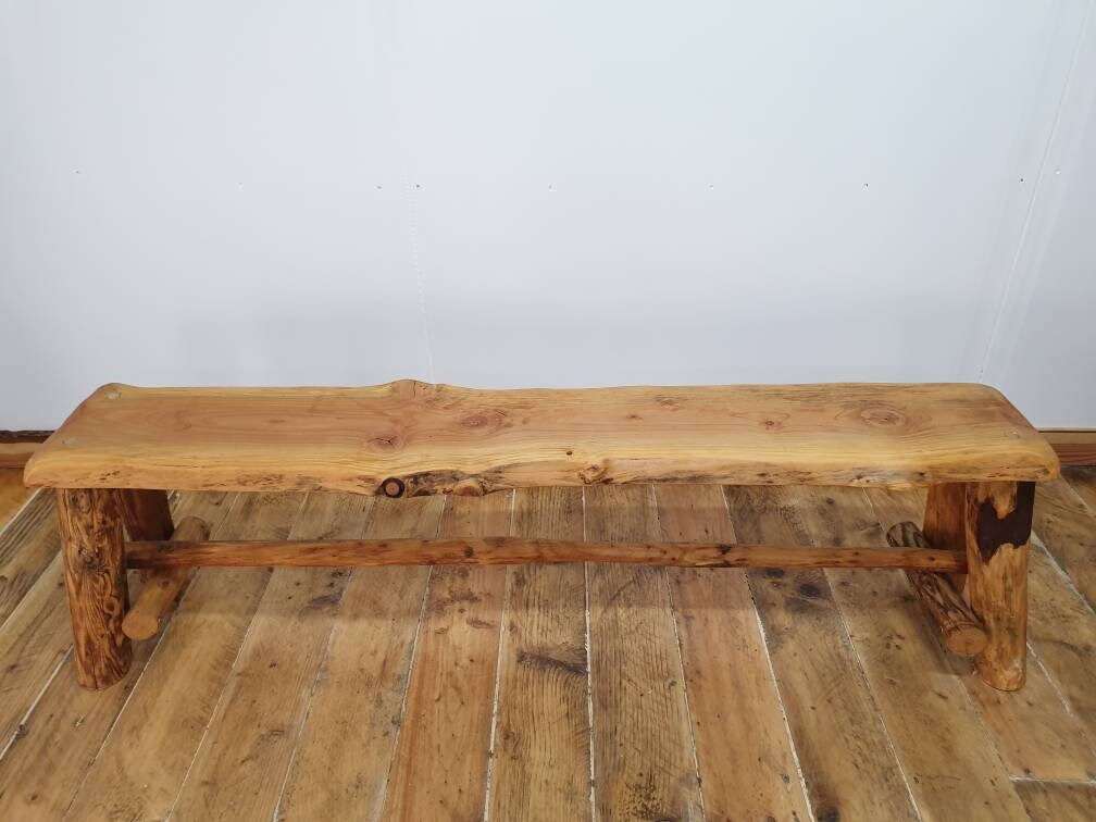 A front view of a wooden bench showing of the support beam underneath it.