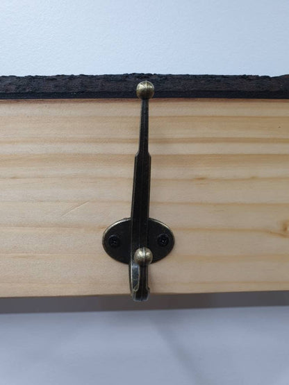 A close up of the hooks used. They are a double hook (one on top of the other) in a tarnished brass finish, secured with 2 small, black, countersunk screws.