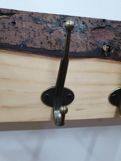 A close up of the hooks used. They are a double hook in a tarnished brass finish secured by 2 small black screws.