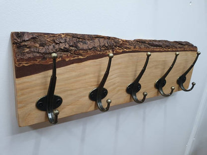 A photo of the previous douglas fir 5 hook coat rack from the left aspect. It has a creamy colour wood grain and a very defined, layered effect of the cross sectioned bark layer. 